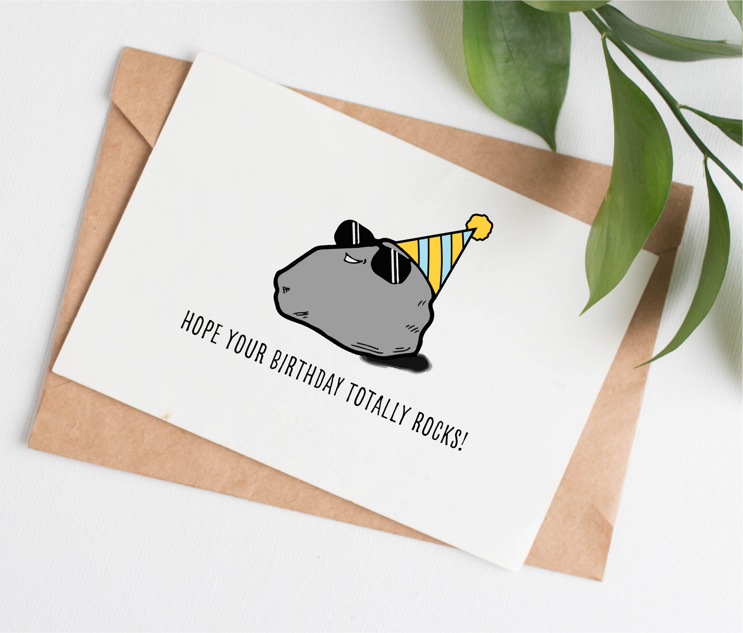 This handmade card is made in Canada. It shows a rock wearing sunglasses and a birthday hat, with a caption that says "Hope your birthday totally rocks!"