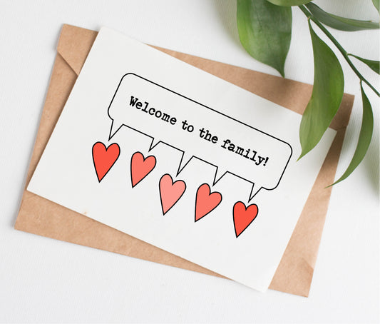 This wedding card is handmade in Canada. It shows 5 pink and red hearts, with a speech bubble coming from all the hearts and the text "Welcome to the family!"